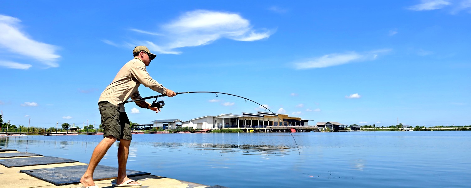 Angler fighting a fish at Giant Bang Len Fishing Lake in Thailand