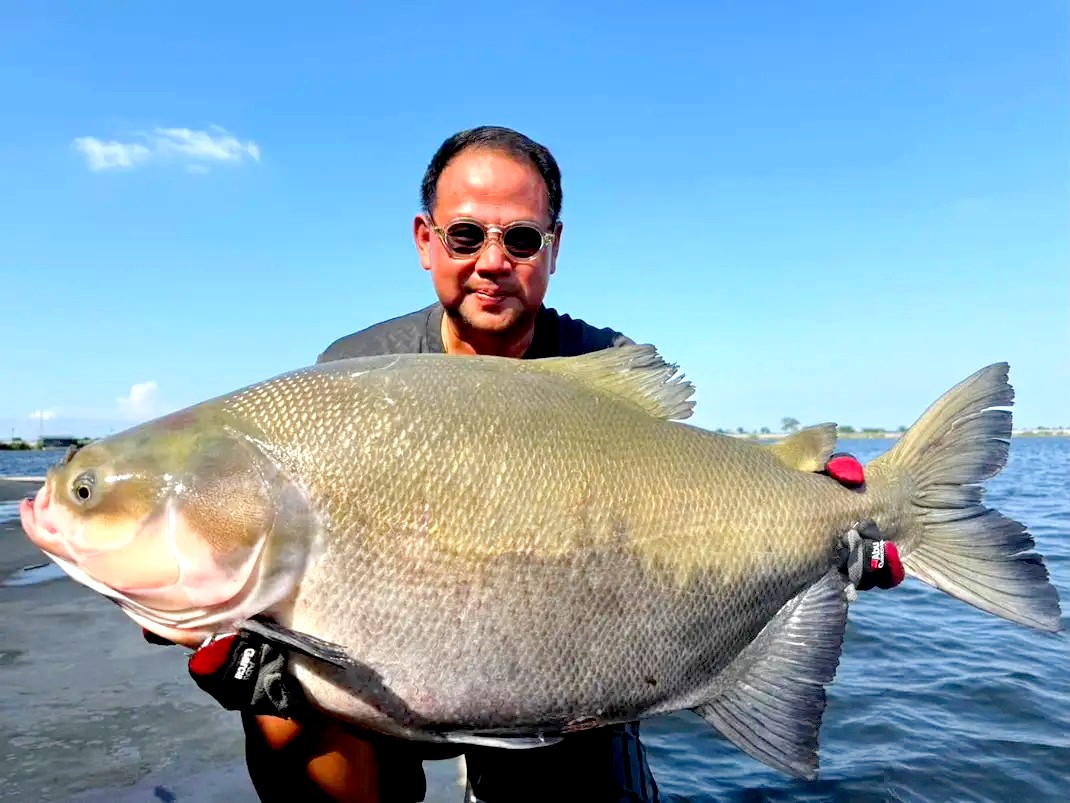 Angler holding a tambaqui caught fishing in Thailand